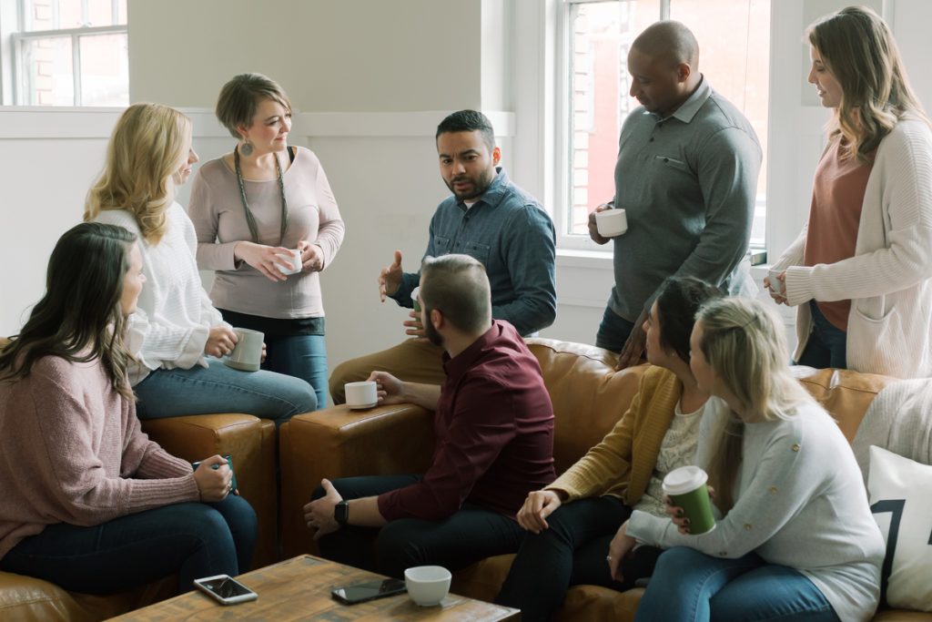 A diverse group of church leaders sitting together in a circle, demonstrating church unity after election divisions.